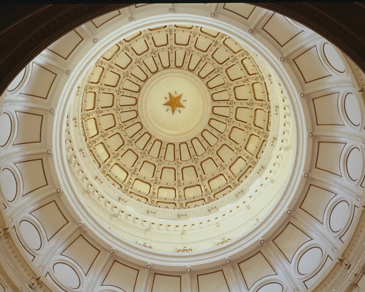 Looking up inside the Texas Capitol dome, with ringed plaster panels and a gold star at the center